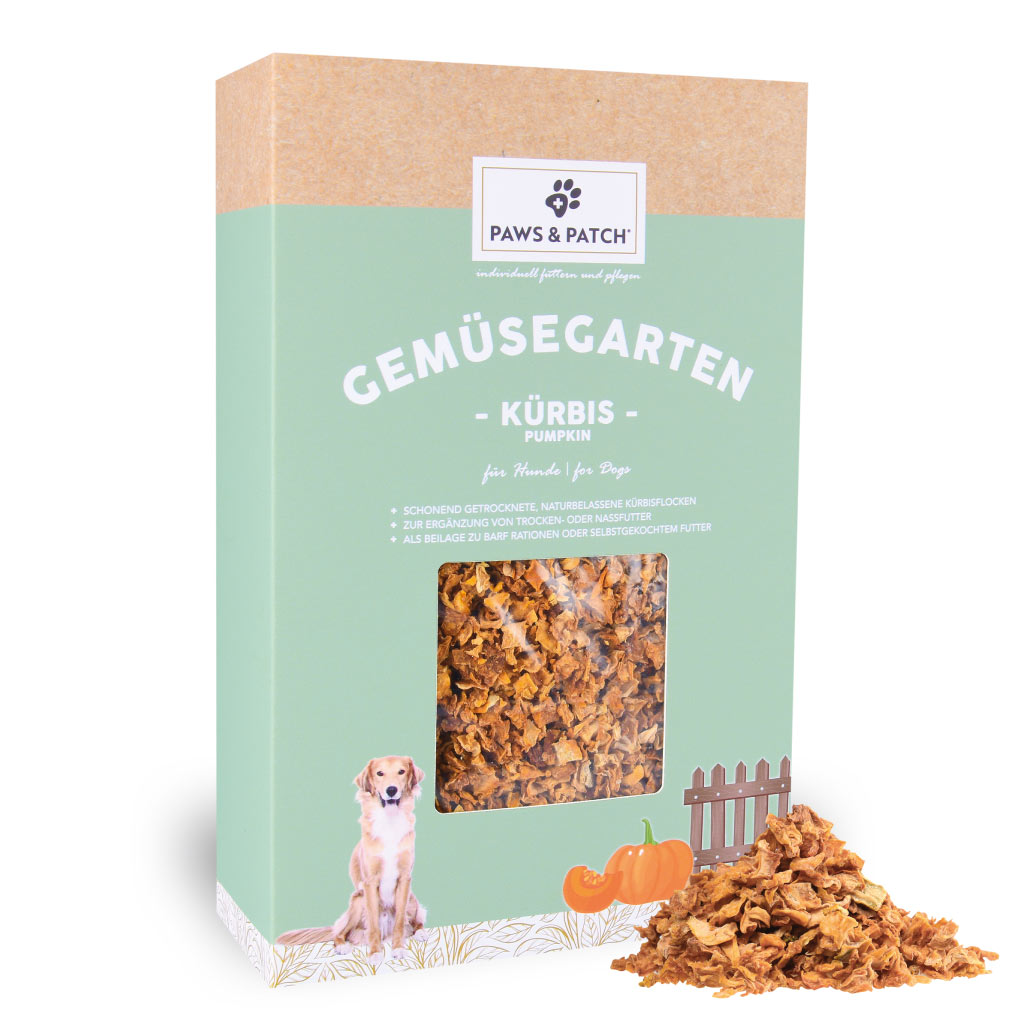 Hellgründe Verpackung aus Pappe mit Sichtfenster, das Kürbisflocken zeigt - davor ein Häufchen ausgepackte Kürbisflocken