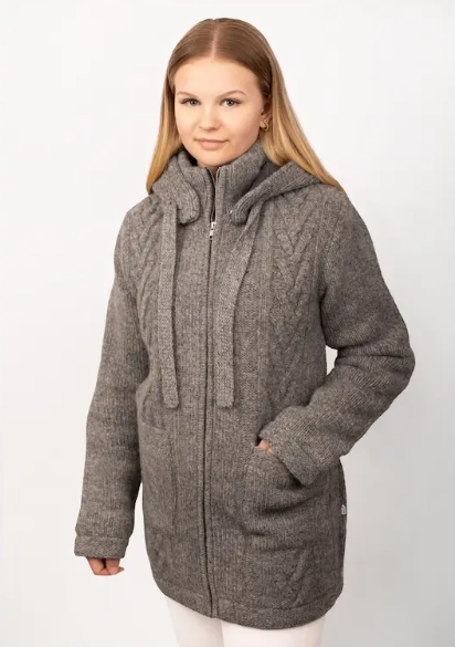 Frau in lindgrünem Wollmantel mit Zopfmuster